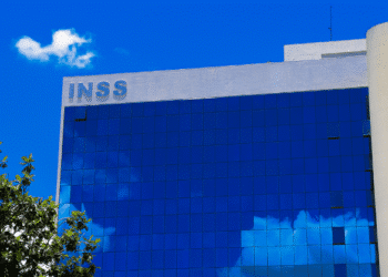 Edifício do INSS refletido em vidro, tema: mais de 600 mil aposentados podem perder dinheiro por não assinar acordo.