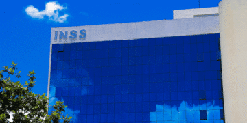 Edifício do INSS refletido em vidro, tema: mais de 600 mil aposentados podem perder dinheiro por não assinar acordo.