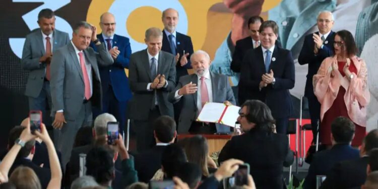 Presidente Lula assinando o decreto da TV 3.0 com autoridades e público ao redor