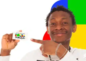 Homem sorridente segura cartão do programa Bolsa Família e aponta para ele com fundo colorido.