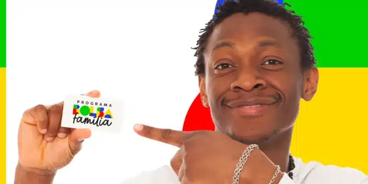 Homem sorridente segura cartão do programa Bolsa Família e aponta para ele com fundo colorido.