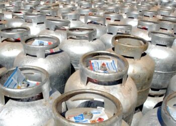 Dezenas de botijões de gás empilhados em um galpão.