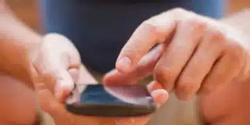 Pessoa consultando o celular para obter informações sobre o Vale Gás 2025.
