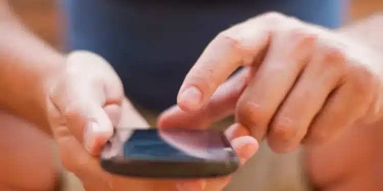 Pessoa consultando o celular para obter informações sobre o Vale Gás 2025.