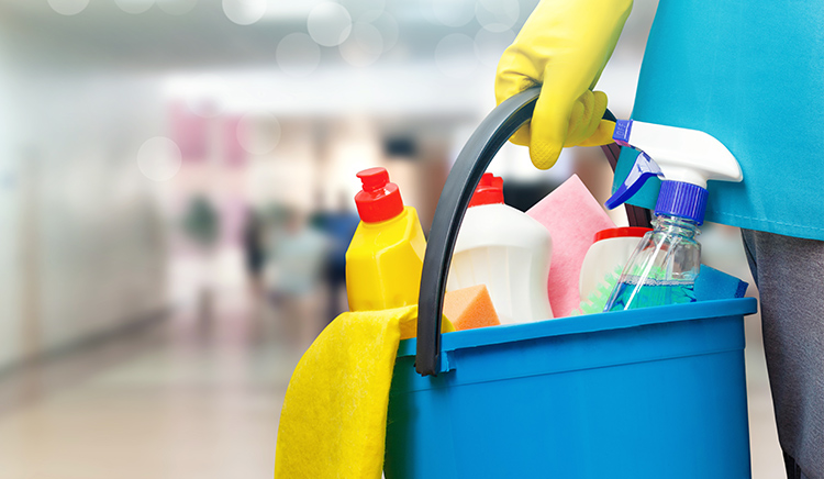Imagem de um balde de limpeza com diversos produtos de limpeza em um ambiente de trabalho, simbolizando a ação de regularização e cuidados com obrigações, como o FGTS.