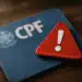 Cartão de CPF com símbolo de alerta em cima