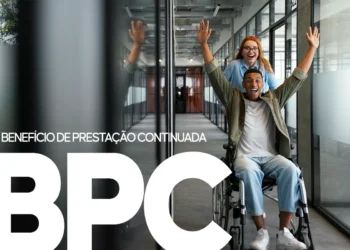 Homem sorridente em cadeira de rodas, sendo empurrado por uma mulher em um escritório, com as letras 'BPC' em destaque, ilustrando o recebimento do benefício.