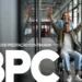 Homem sorridente em cadeira de rodas, sendo empurrado por uma mulher em um escritório, com as letras 'BPC' em destaque, ilustrando o recebimento do benefício.