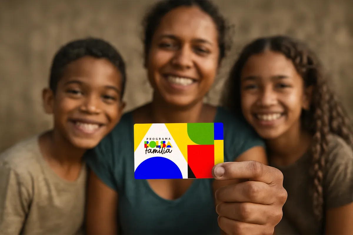 Família sorridente com a mãe segurando o cartão do Bolsa Família, representando os critérios e as responsabilidades para a manutenção do benefício.