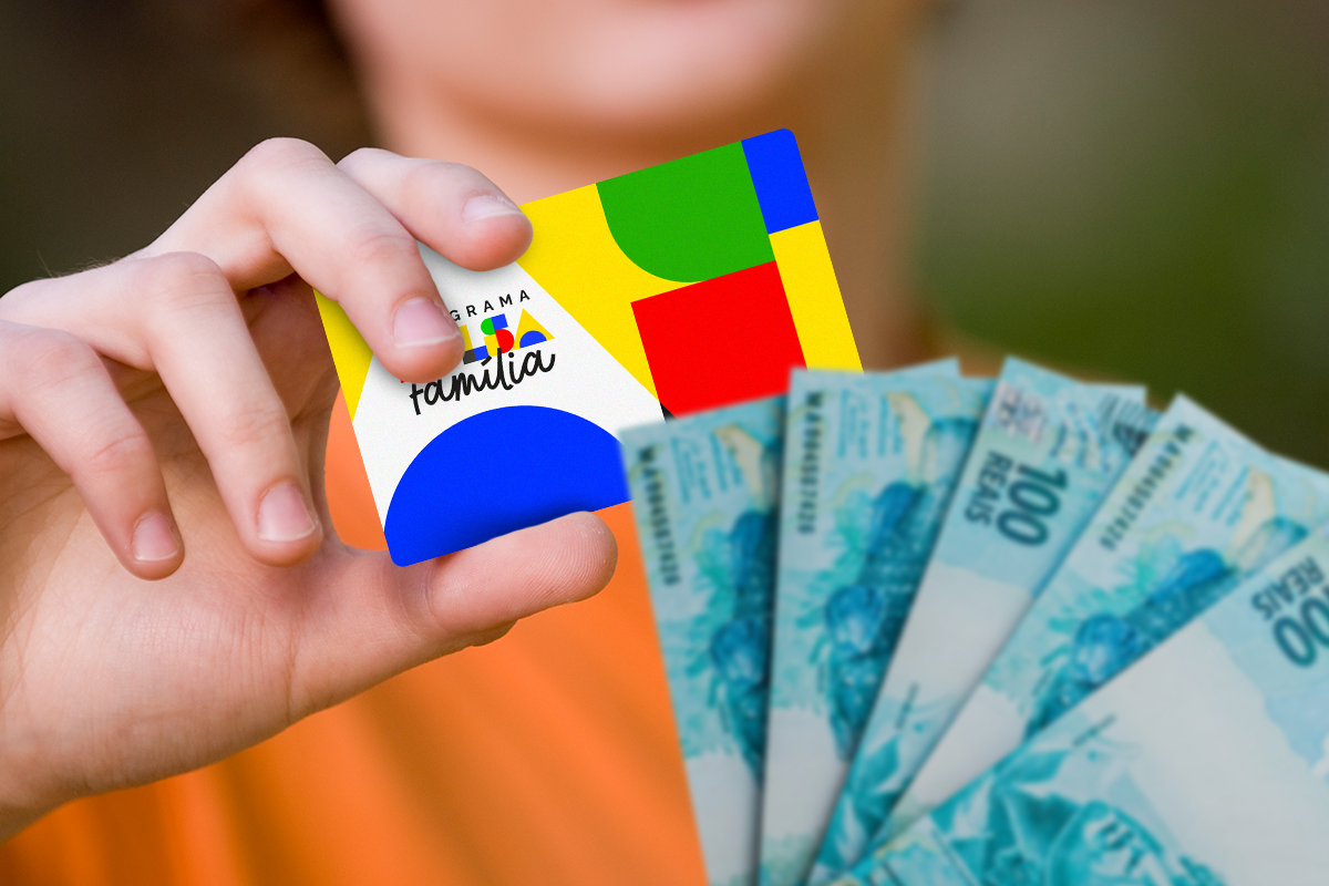 Uma mão segurando o cartão colorido do Programa Bolsa Família, com o logo do governo federal, e outra mão segurando um leque de notas de cem reais.