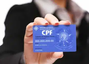 essoa segurando cartão de CPF, representando consulta e situação de crédito negativado em 2025.