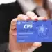 essoa segurando cartão de CPF, representando consulta e situação de crédito negativado em 2025.
