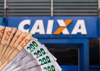 Cédulas de real em frente à agência da Caixa Econômica Federal