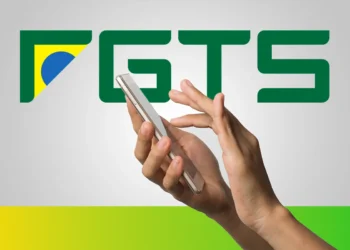 Pessoa segurando um smartphone com o logo do FGTS ao fundo, representando o acesso ao crédito do FGTS pelo celular.