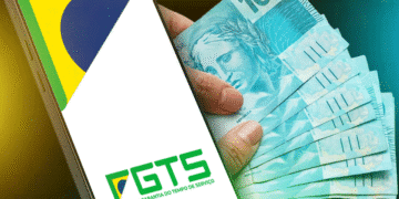 Notas de 100 reais com celular exibindo aplicativo do FGTS.
