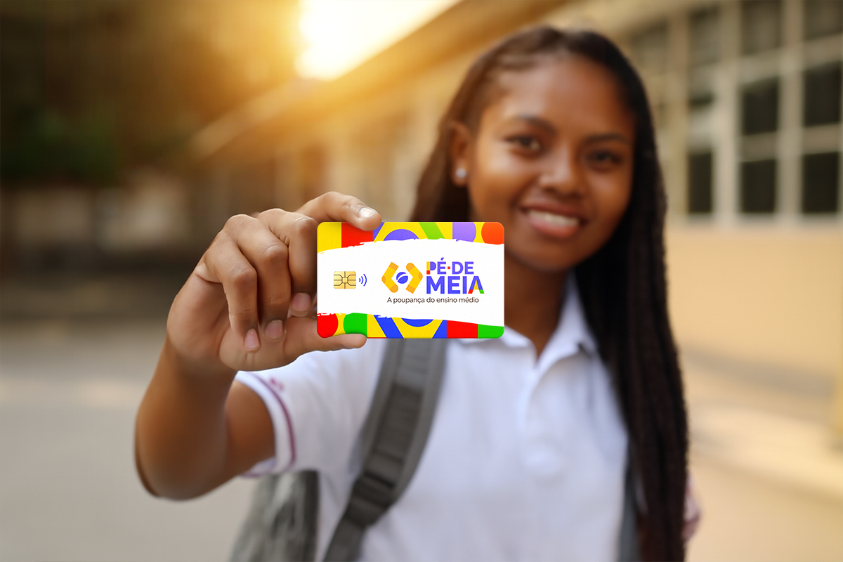 Estudante segura cartão colorido do programa Pé-de-Meia, com uniforme escolar e fundo de escola