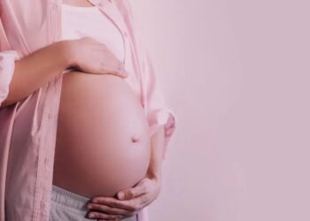 Imagem de mulher grávida, com mãos sobre a barriga, simbolizando proteção e apoio à licença-maternidade no Brasil.