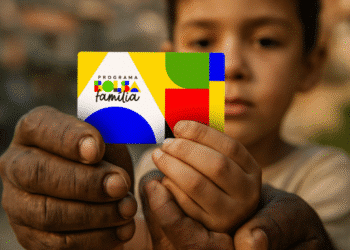 Criança segurando cartão do Programa Bolsa Família.