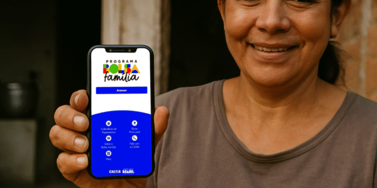 Mulher sorridente segura celular com aplicativo do Bolsa Família aberto na tela.