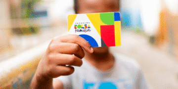 Criança segurando cartão do Bolsa Família