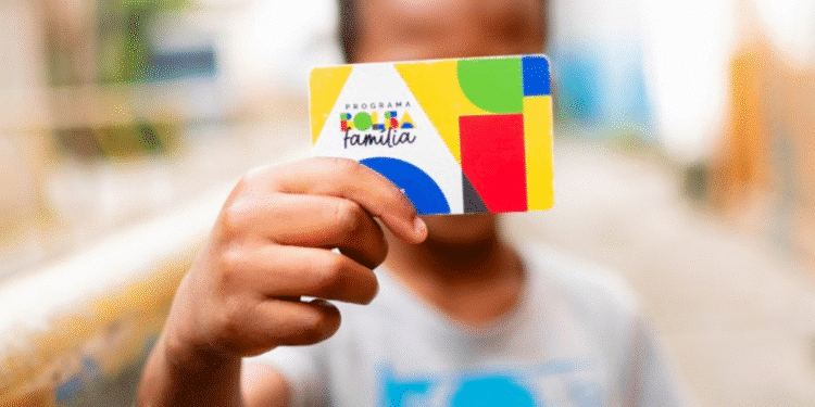 Criança segurando cartão do Bolsa Família