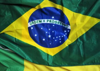 Close-up da bandeira do Brasil com a frase "Ordem e Progresso" e as estrelas visíveis, simbolizando a celebração da Independência no dia 7 de setembro.