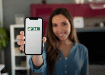 Mulher segurando celular com aplicativo FGTS aberto na tela