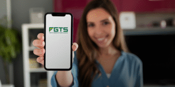 Mulher segurando celular com aplicativo FGTS aberto na tela