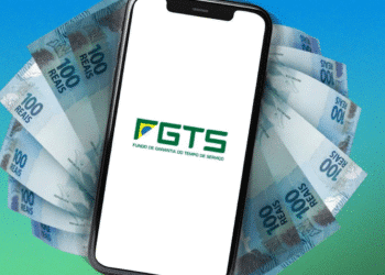 Smartphone com logo do FGTS na tela, rodeado por cédulas de 100 reais
