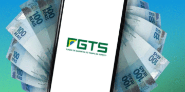 Smartphone com logo do FGTS na tela, rodeado por cédulas de 100 reais