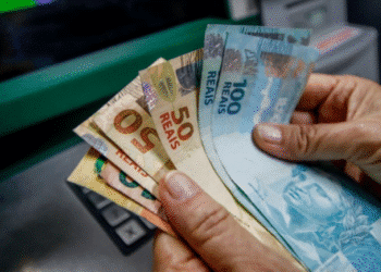 Dinheiro em espécie sendo sacado em caixa eletrônico