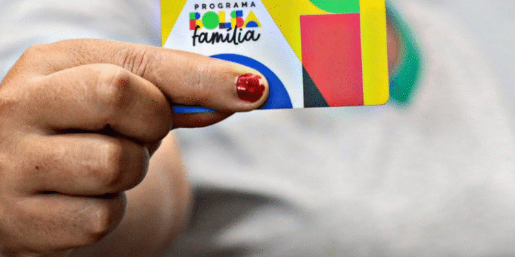 Cartão do Bolsa Família sendo segurado por uma pessoa.