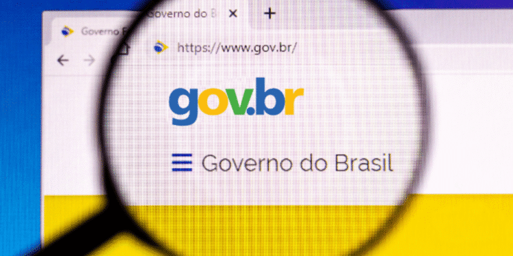Foto de uma página do site gov.br com o logotipo "gov.br" e a frase "Governo do Brasil" sob uma lupa, destacando um anúncio de benefícios.