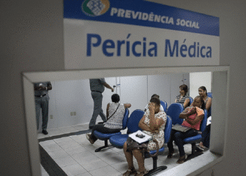 Sala de espera da perícia médica do INSS com pessoas aguardando atendimento.