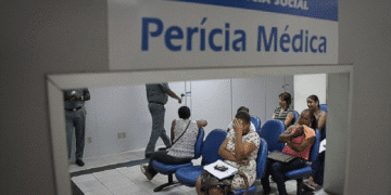 Sala de espera da perícia médica do INSS com pessoas aguardando atendimento.