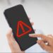 Alerta de golpe: celular com símbolo de aviso de ligação suspeita