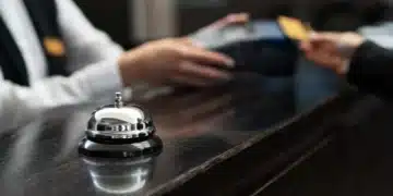 Recepcionista em hotel com uniforme formal, simbolizando mudanças nas regras de hospedagem.