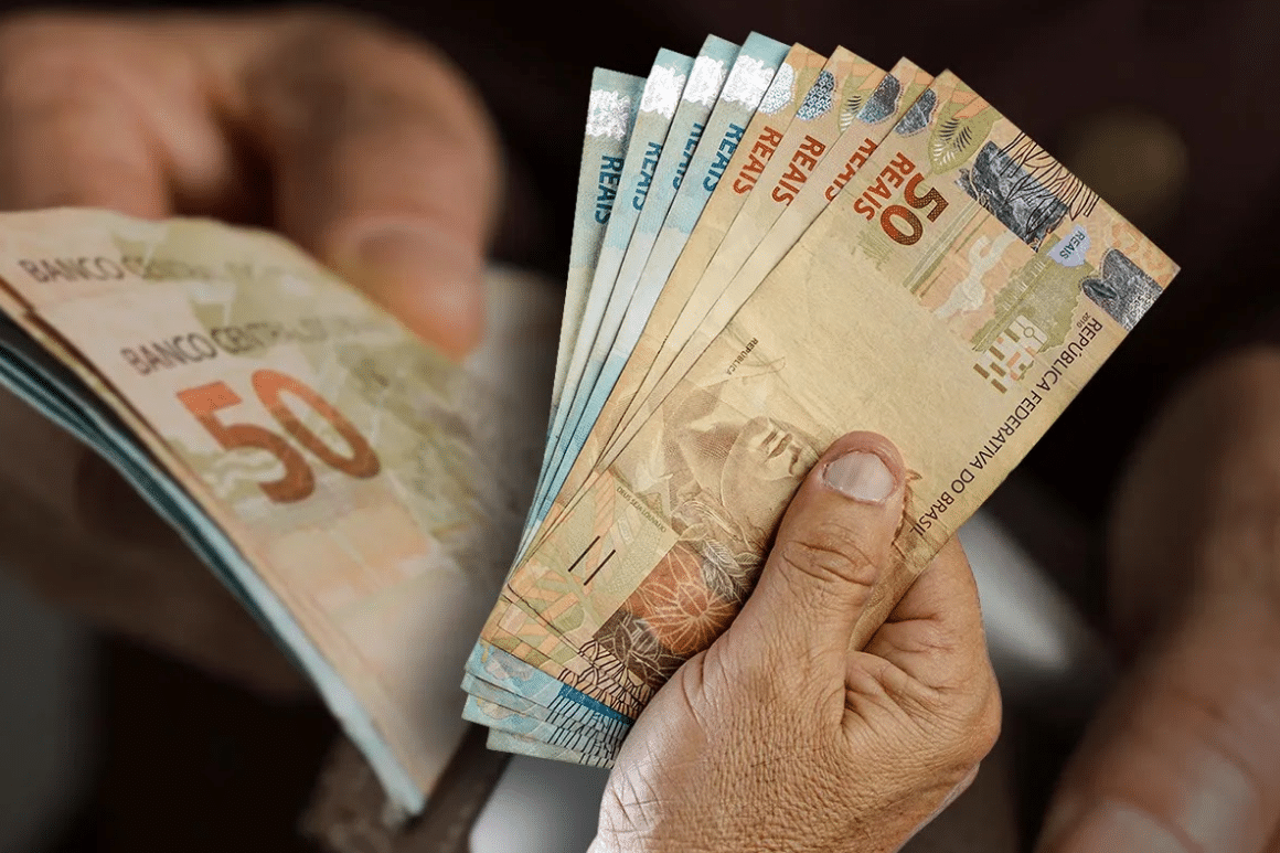 Pessoa segurando notas de real.