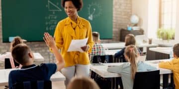Professora interagindo com alunos em sala de aula, com foco na educação e no apoio ao aprendizado
