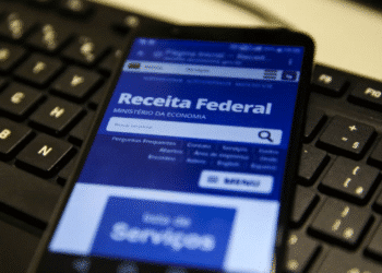Smartphone exibindo site da Receita Federal com notícia sobre o cancelamento do 5º lote de restituição do Imposto de Renda 2025.