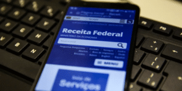 Smartphone exibindo site da Receita Federal com notícia sobre o cancelamento do 5º lote de restituição do Imposto de Renda 2025.