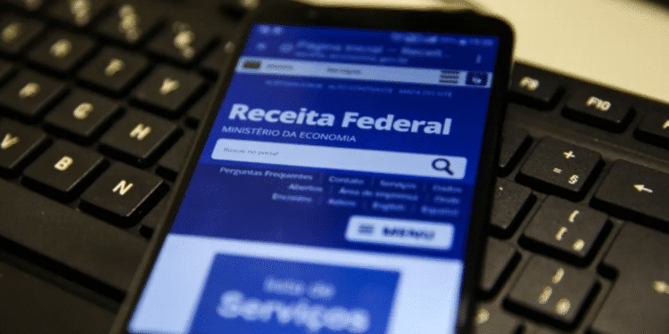 Smartphone exibindo site da Receita Federal com notícia sobre o cancelamento do 5º lote de restituição do Imposto de Renda 2025.
