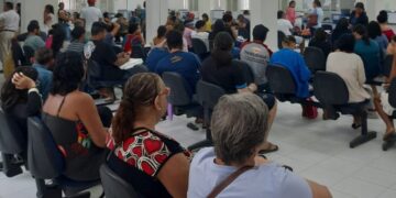 Público aguardando atendimento em cadeiras pretas na sala de espera de uma agência do INSS durante mutirão, visando agilizar a análise de benefícios.