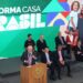 Presidente discursando no lançamento do programa 'Reforma Casa Brasil', com um telão exibindo famílias felizes e autoridades presentes.