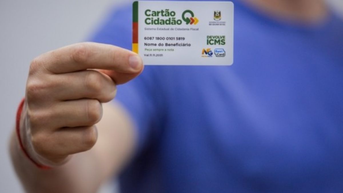 Foto em close-up de uma mão segurando o Cartão Cidadão Devolve ICMS, que é usado para receber os repasses e consultar o saldo do benefício no Rio Grande do Sul.
