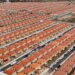 Vista aérea de um grande conjunto habitacional com casas padronizadas, simbolizando a moradia e reformas.
