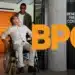 Imagem de um homem em cadeira de rodas sendo ajudado por outra pessoa, com a sigla BPC destacada em laranja e informações sobre o benefício de prestação continuada.
