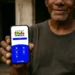 Homem segurando smartphone com tela do aplicativo Bolsa Família, do programa social da Caixa Econômica.