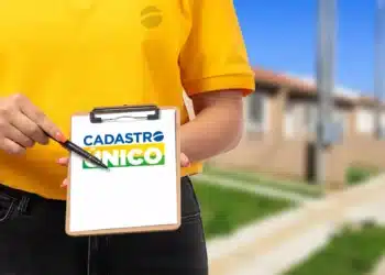 Representação do Cadastro Único (CadÚnico) em uma prancheta sendo apontada por uma pessoa, simbolizando o registro de famílias para programas sociais.