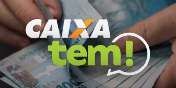 Logo do aplicativo Caixa Tem sobre notas de R$ 100 em mãos de alguém, representando a movimentação de pagamentos sociais como o Auxílio Gás.